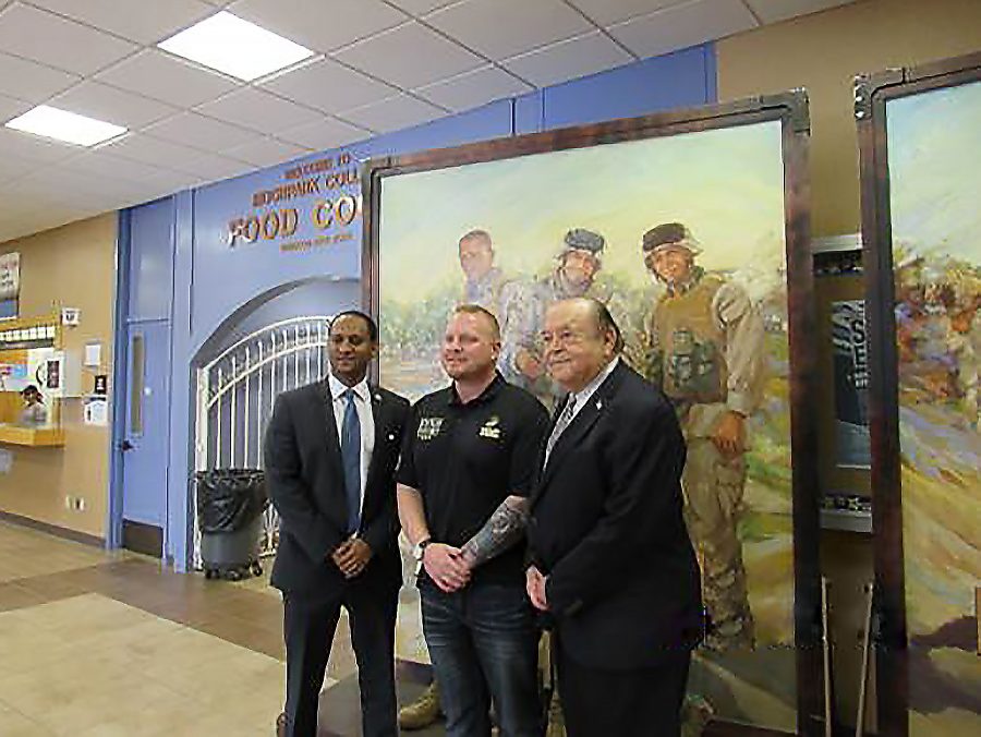 Dr. Amanuel Gebru, dean of behavioral sciences (left), Mike Strahle, Eyes of Freedom director (center), and Dr. Bernard Luskin, Ventura Community College District chancellor (right), pose in front of one of the paintings in the gallery. The Eyes of Freedom gallery was set up in the campus center from March 27 to 31. Photo credit: Mary Altshuller