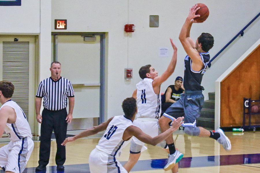 Moorpark College shooting guard Ethan Hermann attempts a fadeaway jumper over defenders. Photo credit: Eric Hermann
