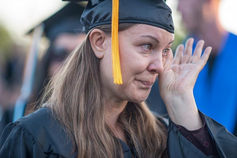 Near the end of the ceremony, a graduating student wipes tears from her eyes as she approaches the podium. Photo credit: James Schaap