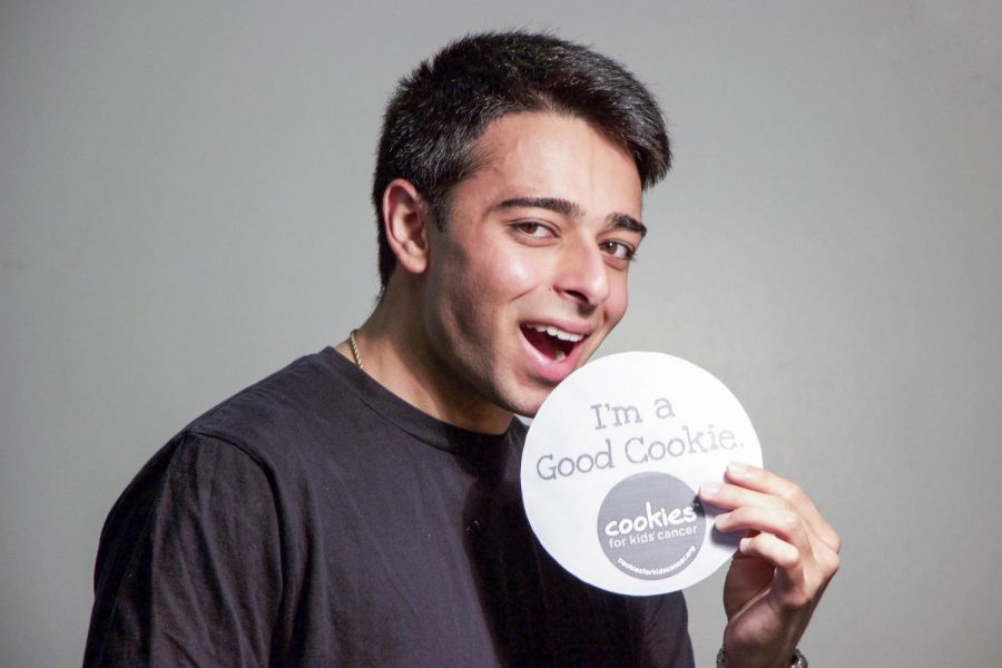 Jay Madhok, President of the Cookies For Kids' cancer club, eats the organization's cookies logo. Photo credit: James Schaap