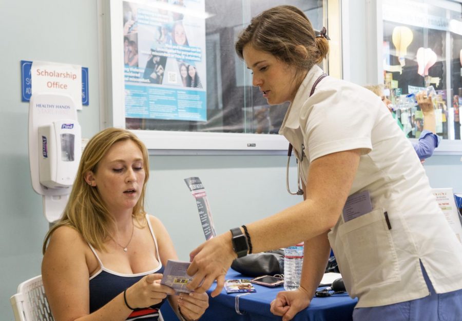 Sandra Daughenhaugh, 20, kinesiology major (left) is instructed on keeping healthy blood pressure levels by Rebecca Pancake, 29, nursing student. Students got the opportunity to measure their blood pressure and body fat in Fountain Hall as part of the Health Centers Heart Health Day on Aug. 29 and 30.