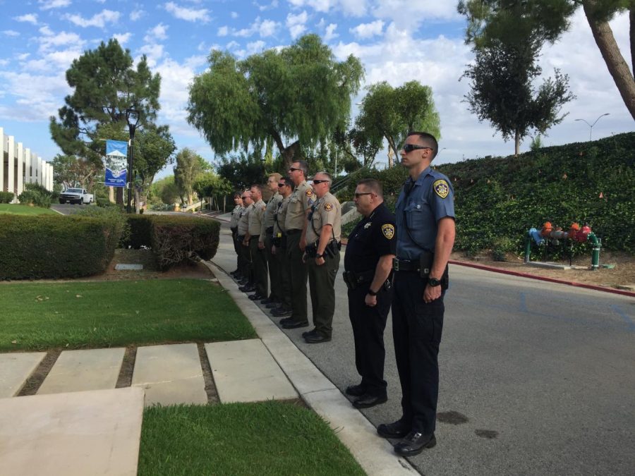Members of the both the campus police and local sheriffs department stand at attention for the flag raising ceremony. The flag was raised at half mast at 8:45 a.m., in memorial of the time when the first plane hit the World Trade Center. Photo credit: Ash Dondeti