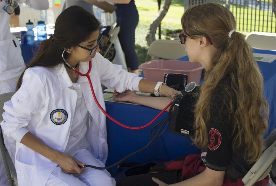 Kaylee Jones, a 19-year-old sociology major, is getting her blood pressure taken by Brandy Moreno, a student nurse at the previous Health Fair. Photo credit: Nikolas Samuels