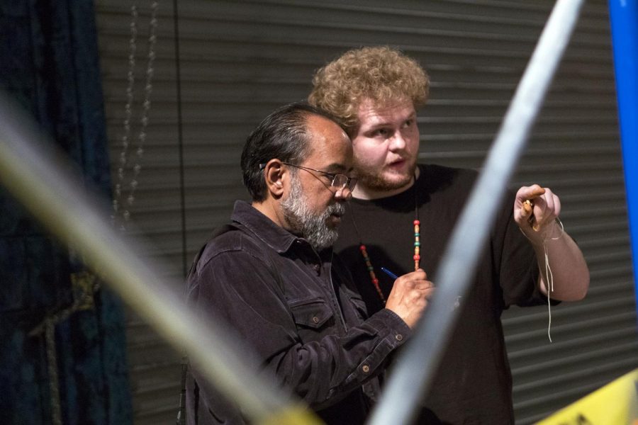 Anacleto Rapping, left, speaks with a student at the Moorpark College Arts Theatre and writes down information to show his students an example of how a photojournalist gathers information.