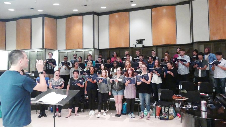 The Moorpark College Choir standing and singing in the vocal arts room in the Music building at Moorpark College. Moorpark College Director of Choral Activities Brandon Elliott conducts, as the choir rehearses for the upcoming Lutheran Legacy concert on Oct. 27 and 28, 2017. Photo credit: Ian Cohen