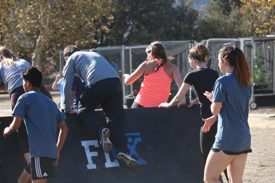 Students jump over an obstacle placed along the course. The challenge this year included brand new obstacles for runners to try and overcome. Photo credit: Travis Bernard