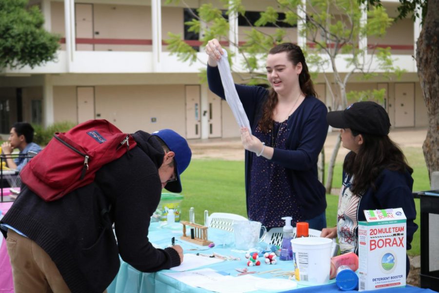 Materials Engineering major Erika Szaldobagyi, center, and Chemistry major Amanda Davis, right, showcase their chemistry club during the Fall 2017 club rush. Together they demonstrated slime made from common household products as prospective members signed up for an email list. Photo credit: Student Voice Archive