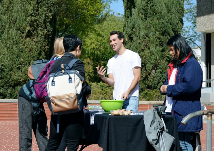 Students sign postcards and speak with Chris Luczwyek, center, and Arisay Diaz, right, about the DACA program outside of Fountain Hall. Photo credit: Kendall Sattler