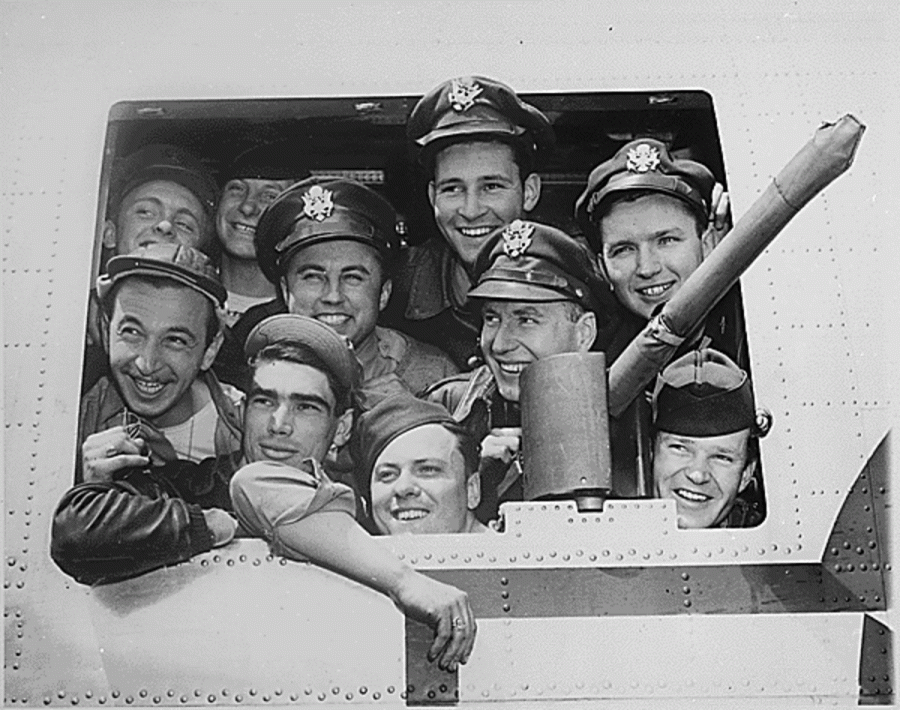 Yank airmen smile out of the window of their bomber, "Hell Hen", following their arrival at Bradley Field, Windsor Locks, Connecticut, May 22. They helped to bomb Germany out of the war. Photo credit: Press Association, 1945