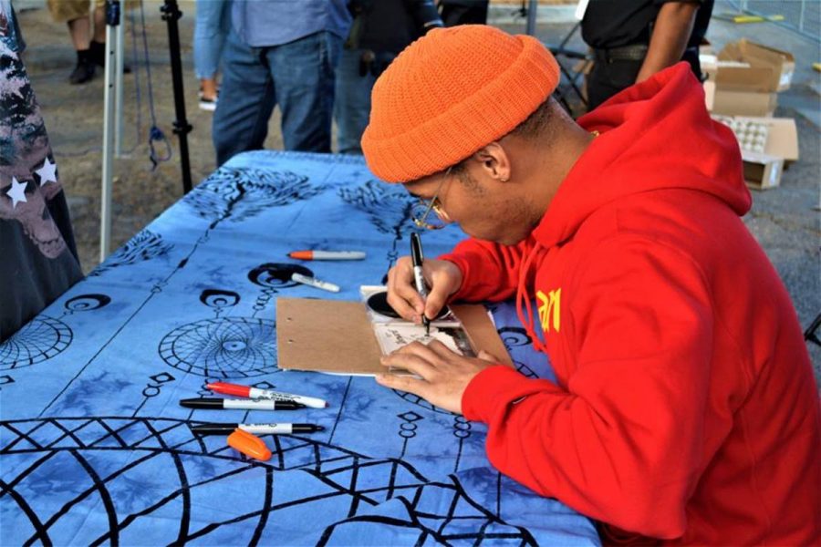 Anderson .Paak signing a copy of his album Oxnard, at his free carnival. Photo credit: Manuel Herrera