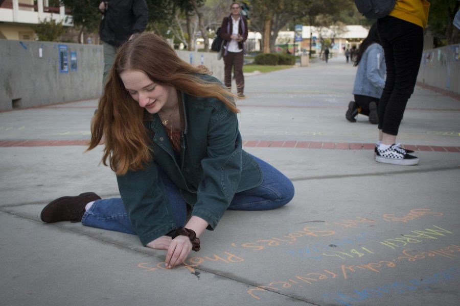 Suzi Bloom, an English major, creates chalk advertisements for the Moorpark Review on Raider Walk, on Feb. 5, 2019. Bloom is the editor for the Student Essay Anthology section. Photo credit: Evan Reinhardt