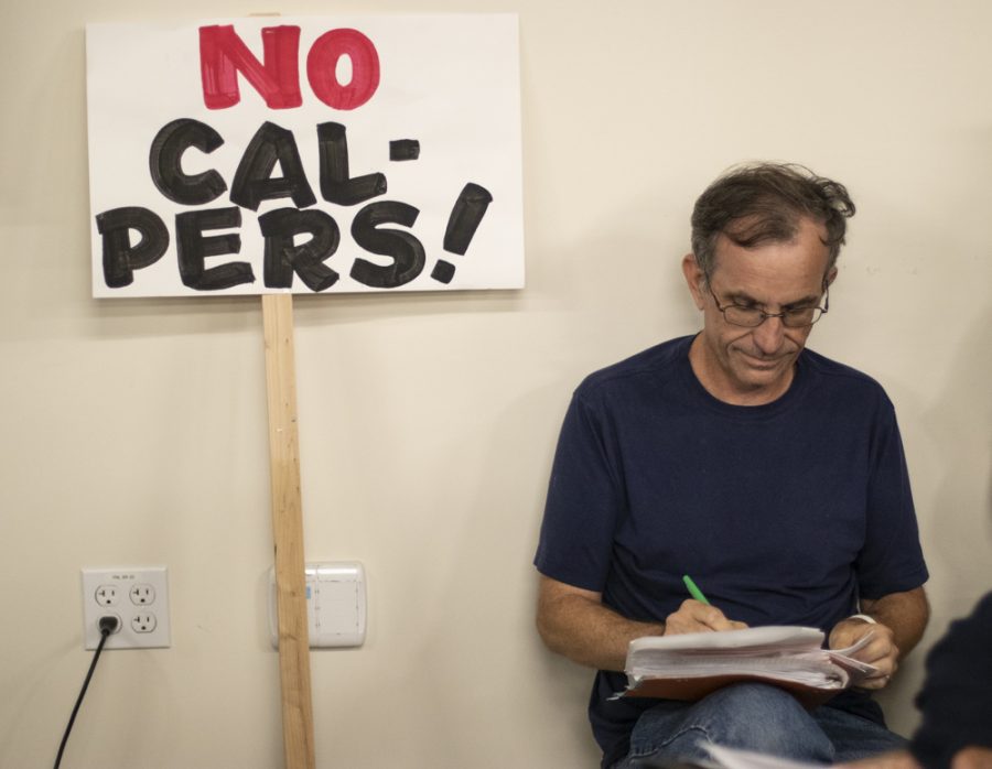 Joe Selzler, chemistry professor at Ventura College, grades papers as he protests the Trustees proposal during the open session meeting on Tuesday, Sept. 10, in Camarillo, Calif. According to Selzler, full-time professors have gone three years without a raise, and a fourth would be, redunkulous. Photo credit: Evan Reinhardt