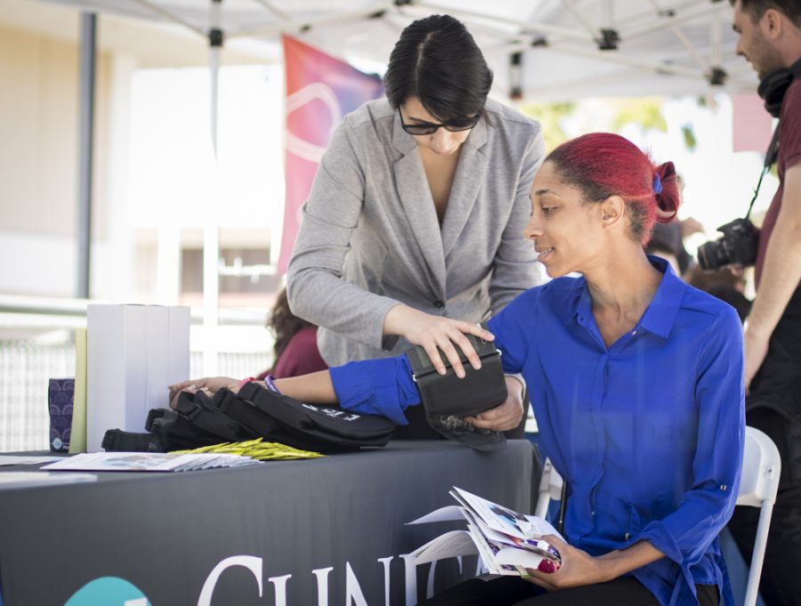 Samantha Perez, representative from Clinicas del Camino Real, tests the blood pressure of Angie Taylor, a representative from Khanna Vision Institute, during the Health Fair. The fair was held on Raider Walk on Tuesday, Oct. 1. Photo credit: Evan Reinhardt