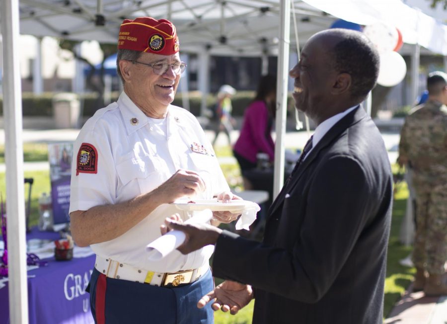 Ken Doc Honaker laughs with Julius Sokenu, Interim President of Moorpark College, during the Veterans Day celebration in the quad on Tuesday, Nov. 13. The event honored the members of the Moorpark community that served in the military. Photo credit: Evan Reinhardt