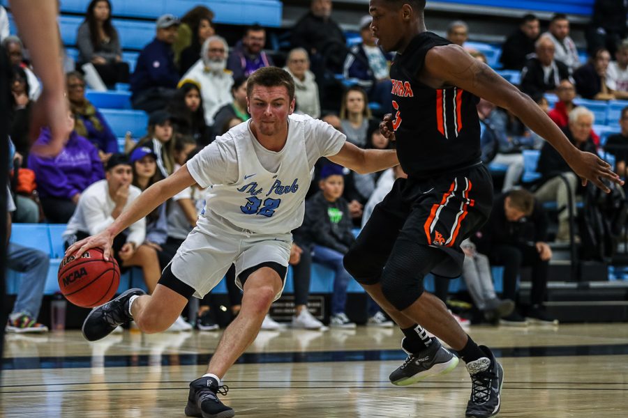 Colton Hage works his way around Ventura College’s Dayveon Bates during their conference game at home on Saturday, Jan. 18.  Ventura defeated Moorpark 97-91. Photo credit: Jace Kessler