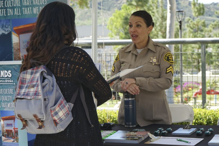 Deputy Weber, 37, from Santa Clarita, informs Moorpark College Biology student Marisol Gonzalez about what jobs the LAPD has to offer at the career expo on March 3. Photo credit: Gavin Woods