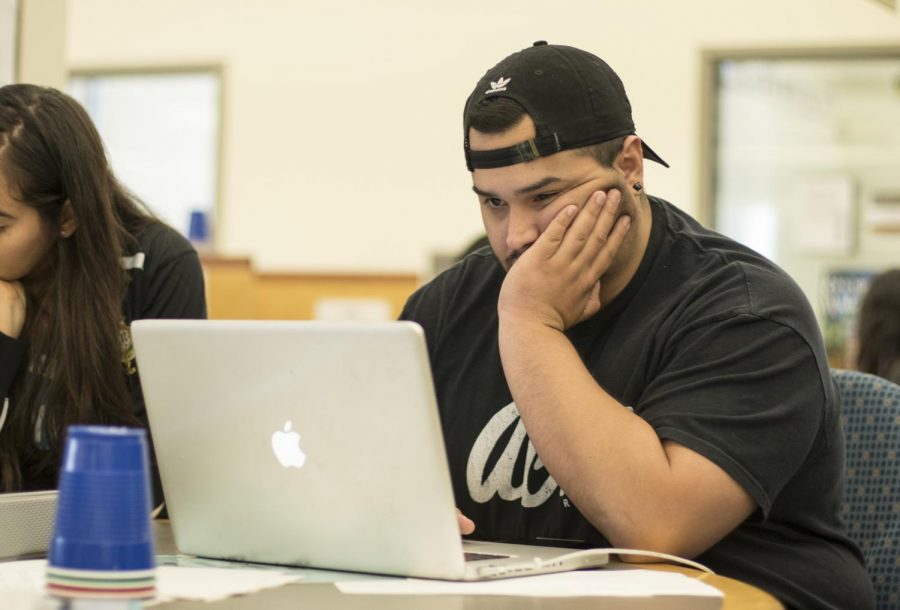 Abe Roca, financial accounting student, studies on his laptop on the third floor of the library on Wednesday, Oct. 16, 2019. Roca says he enjoys the experience of being in a classroom, but understands the value of completing class online. Photo credit: Evan Reinhardt