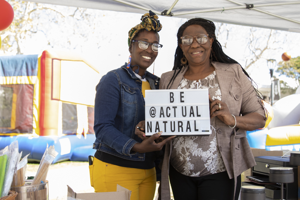 Lakita Davis, left, and Evelyn Davis, mother and daughter, smile for a photo at their booth during the Black Family Reunion on Tuesday, Feb. 24. Both own an all natural hair and skin care company called Actual Natural.
