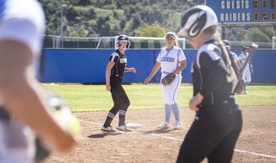 A Renegade base runner watches from third base next to Raider third baseman Alexis DeYoung after the Renegades brought home a batter during moorparks home game on Saturday, Feb. 29. Photo credit: Evan Reinhardt
