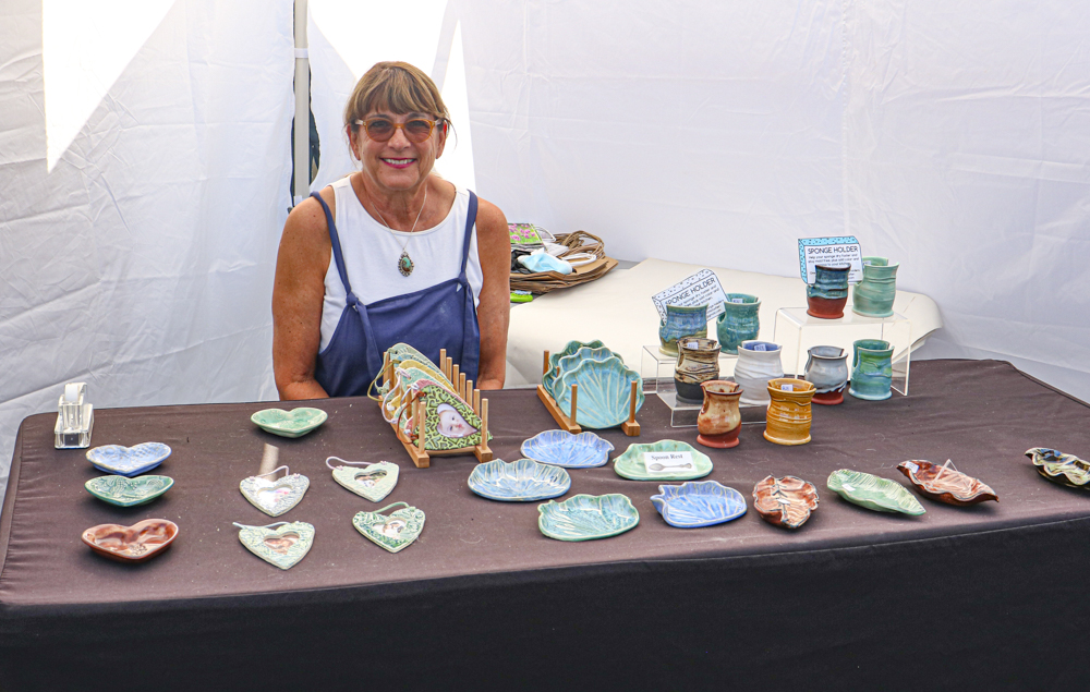 Ellen Wohlstadter sits by her booth and shows her pottery work on Sunday, September 12 in Ventura, CA.