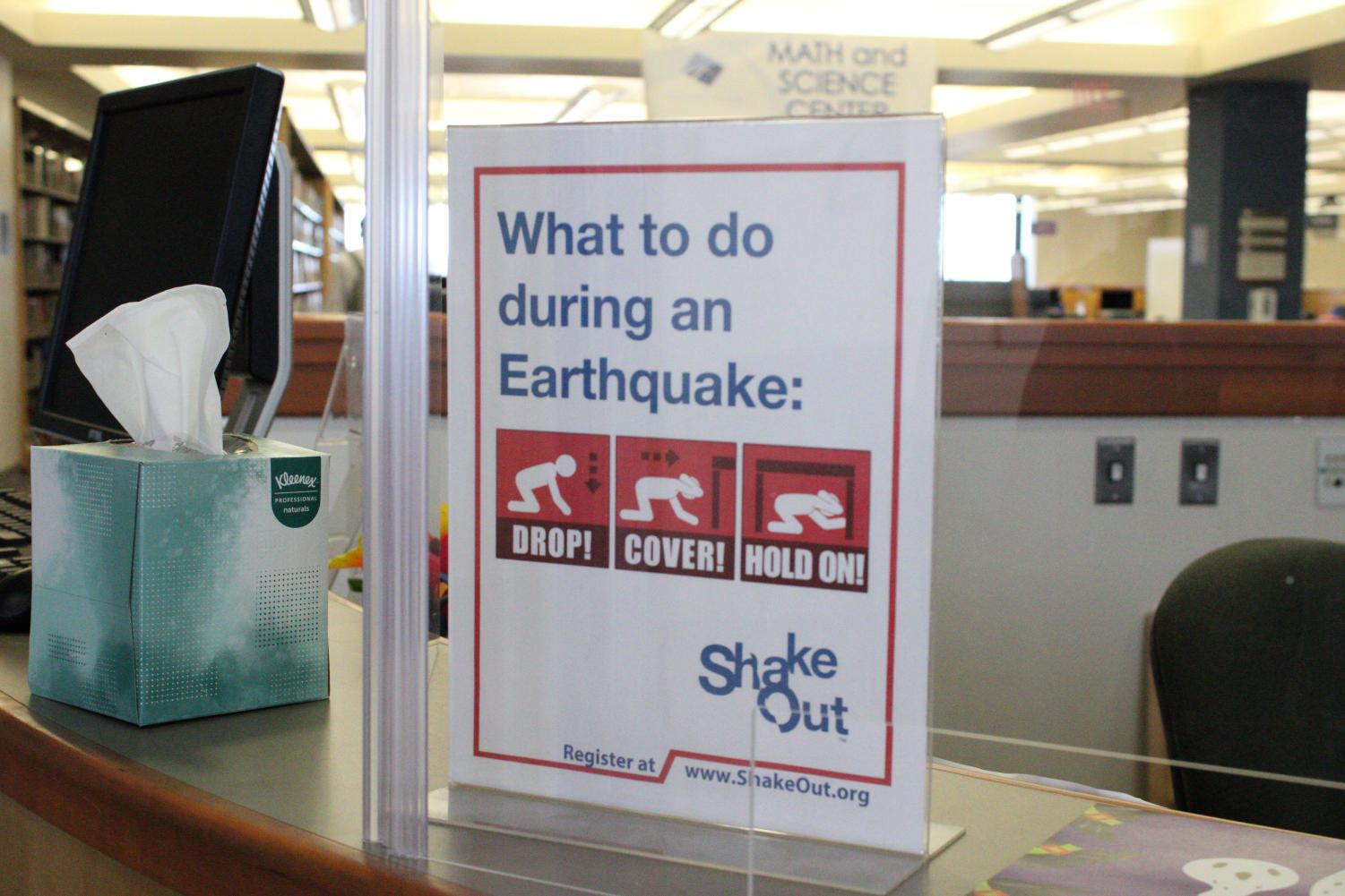 An informational sign sits atop a desk in the Math and Science Center in the Moorpark College Library. It explains the well known "drop, cover, and hold on" instructions to follow during the event of an earthquake.