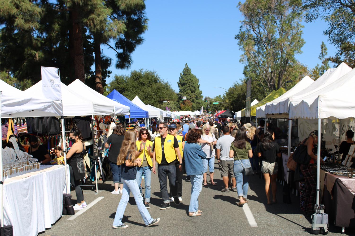 A large crowd of people is seen walking down Moorpark Road and checking out the numerous booths the Rotary Fair had to offer. Booths lined the streets with various things to do.