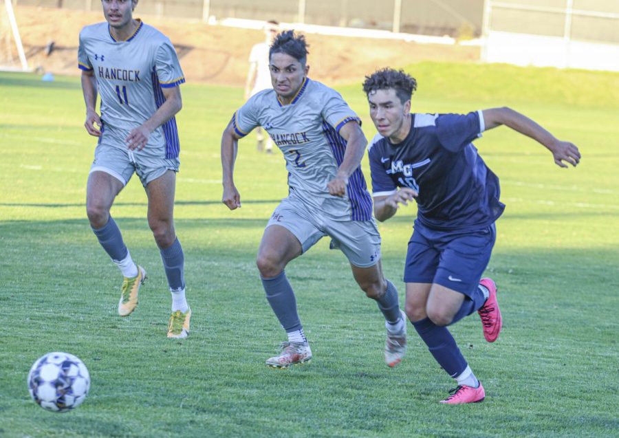 Moorpark freshman midfielder Tony Reyes rushing away from defenders chasing a ball against the defender. Photo taken on Oct. 26 in a game against Allan Hancock College in Moorpark, CA. Photo Credit: Jack Newman.