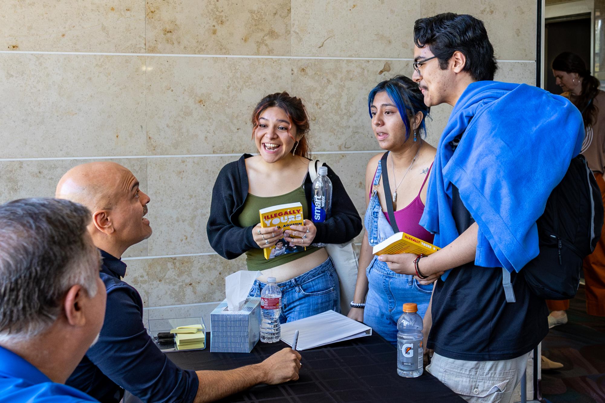 Rafael Agustin speaks to students getting their book signed after the "One Campus, One Book" capstone event on Oct. 17, 2023.