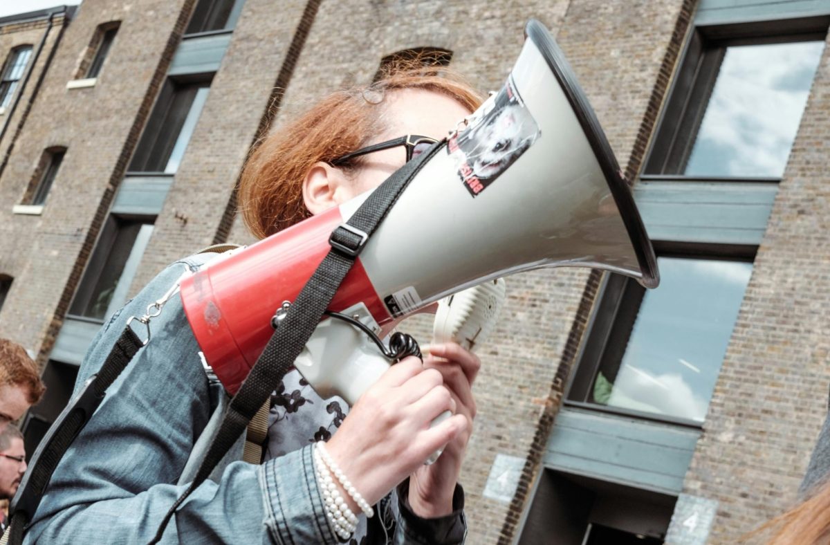 Woman holding a megaphone at a peaceful rally. Photo credit: via Unsplash