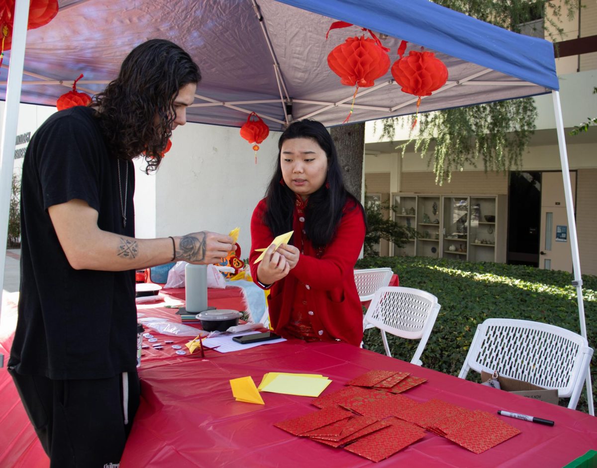 Nikki St Charles (19) instructs Nolan Amos (27) on how to make a paper crane as part of the AAPI Clubs Lunar New Year Event on Feb. 13, 2024 in Moorpark, CA. Photo credit: Matthew Camacho