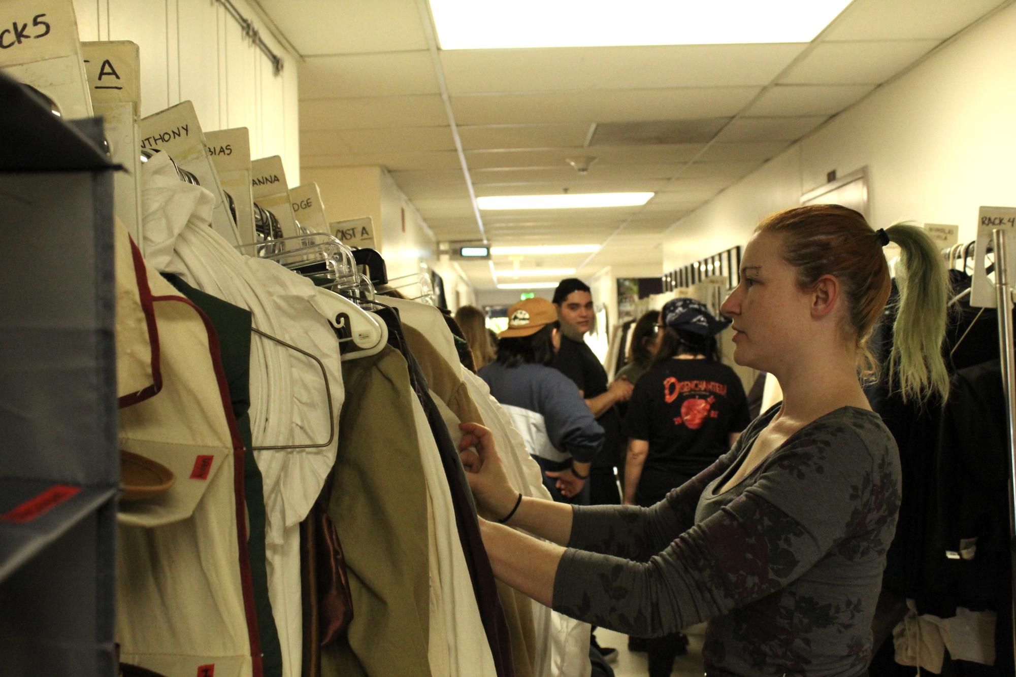 Marina Wagner, a second-year costuming student, sorting through costumes on opening night of "Sweeney Todd: The Demon Barber of Fleet Street" on March 14, 2024.
