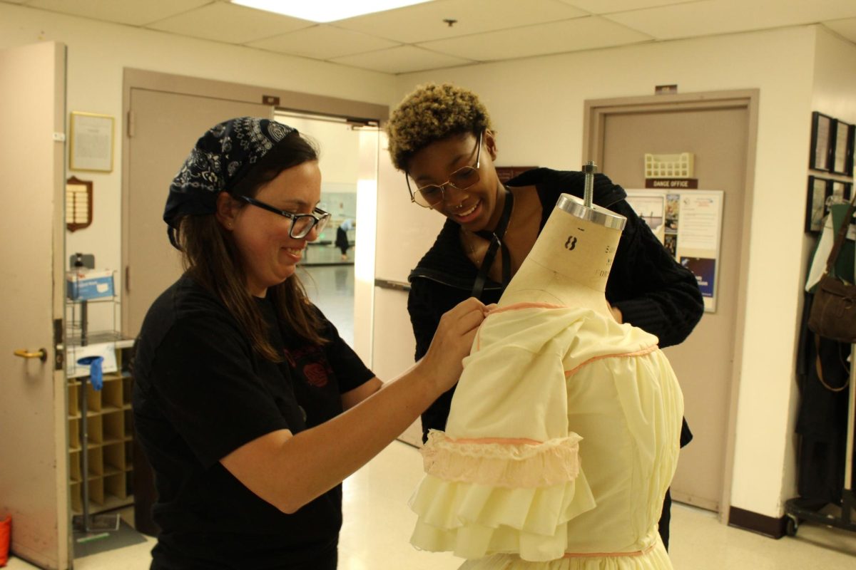 Costume construction and creation crew members Rhiann Olshane and Noa Walker staging a handcrafted dress on the opening night of Sweeney Todd: The Demon Barber of Fleet Street on March 14, 2024. Photo credit: Sarah Graue
