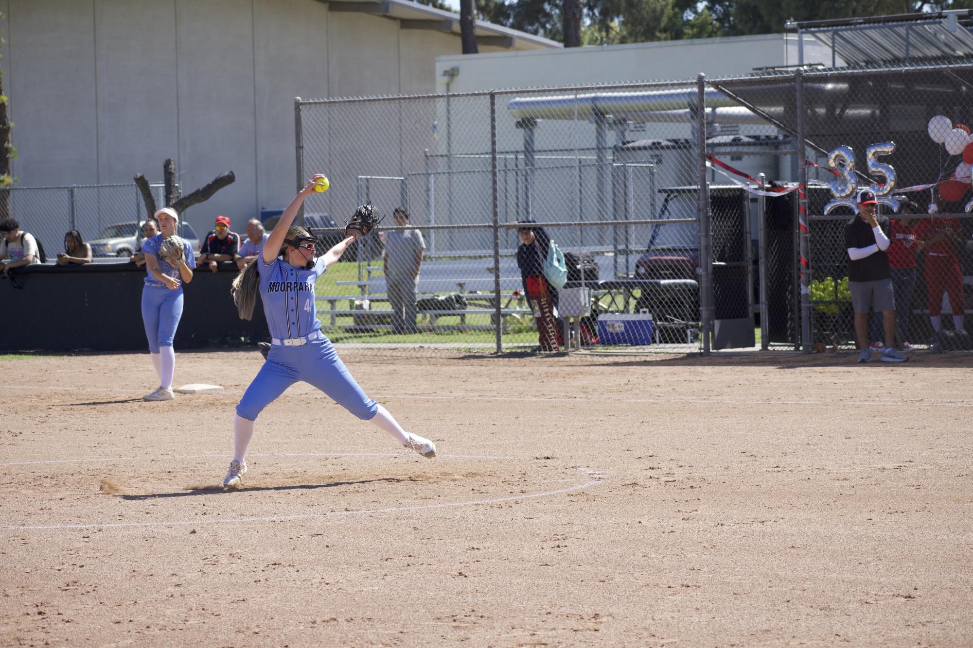 Moorpark College freshman starting pitcher #4 Amanda Smith stays warm in between innings against Pierce College on April 18, 2024.