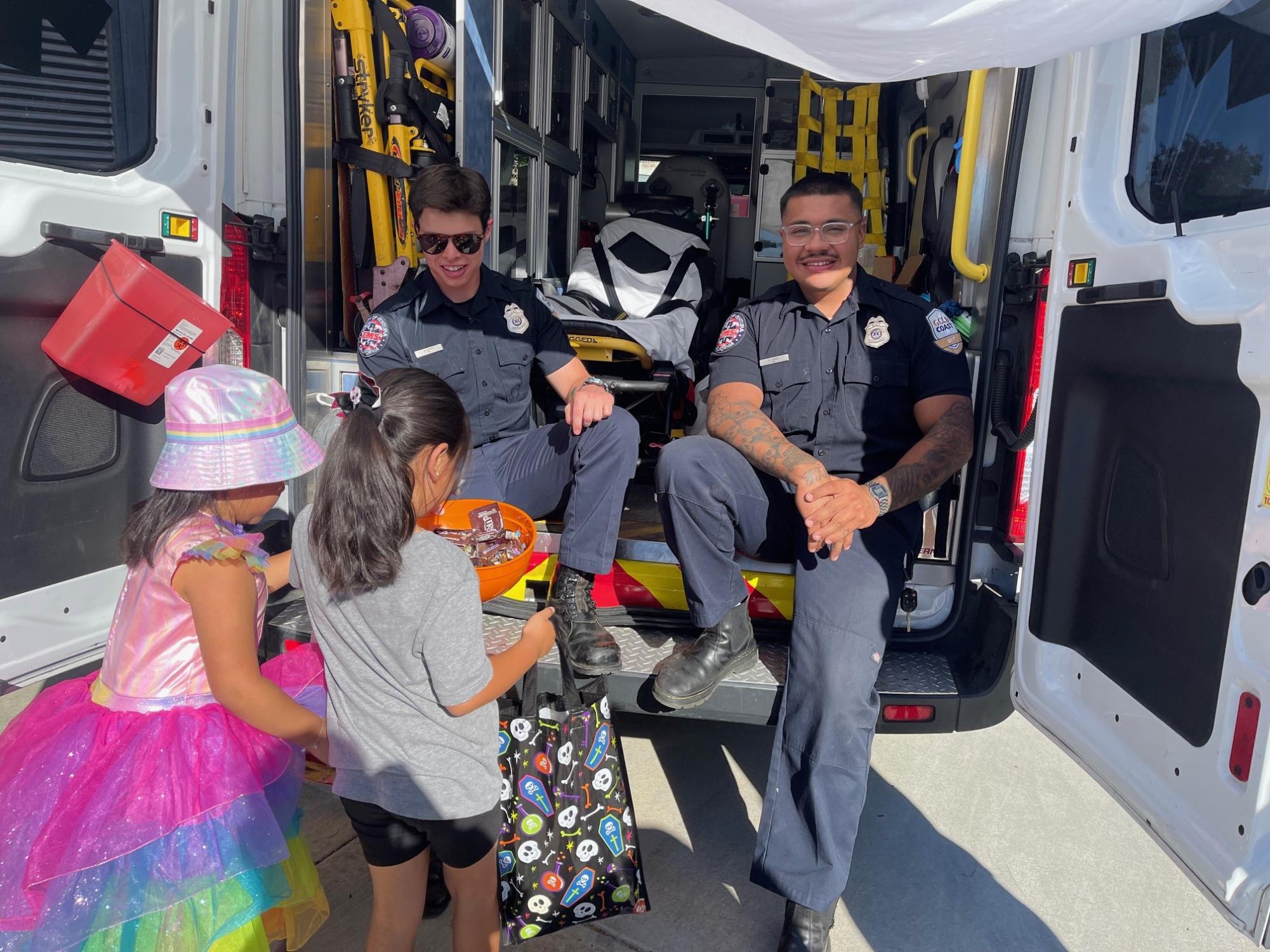 EMT's Austin James (L) and German Suarez (R) enjoy passing out candy while ensuring everyone is safe and healthy. Photo Credit: Madeline Dion