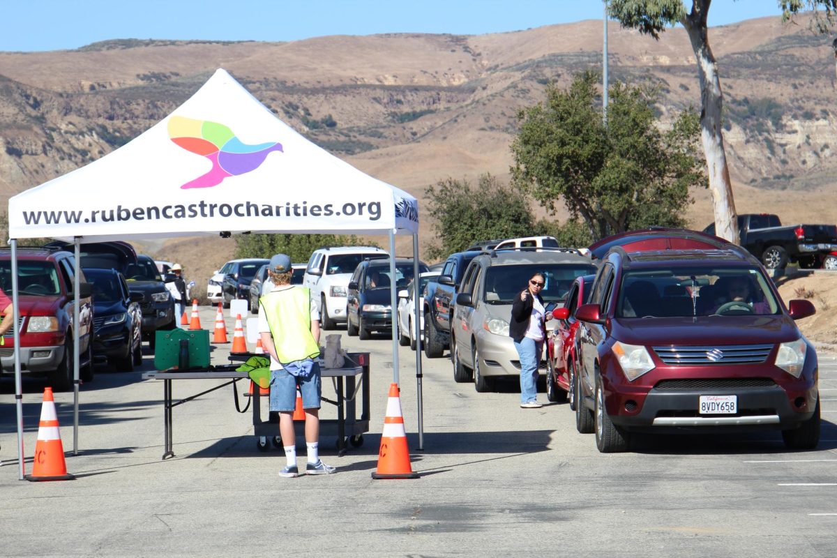 Cars line Moorpark College Parking Lot E, waiting to enter the emergency food distribution pantry one at at time. Families are greeted by volunteers from Food Share of Ventura County and Ruben Castro Charities on Saturday, Nov 9, in Moorpark, Calif. Photo credit: Sarah Graue