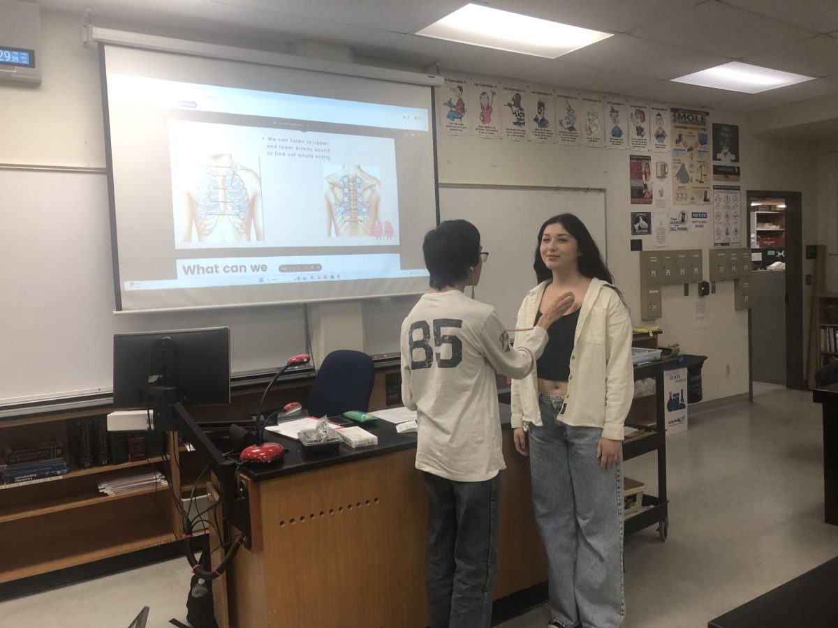 Wesley Lam (left) uses a stethoscope to determine whether Jennifer Kawamoto (right) has healthy breathing patterns. As outlined by Kawamoto, Lam placed the diaphragm of the stethoscope right below the patient's clavicle to ensure bones did not interfere with breathing patterns on Thursday, Oct. 24, 2024 in Moorpark, Calif. Photo credit: Shane Douglas